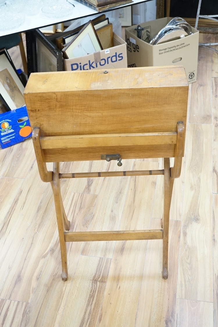 A late 19th century sycamore military folding campaign desk, raised on a trestle stand with X shaped supports, desk section with leather writing surface and folding letter rack, 93cm high, 56cm wide when folded. Conditio